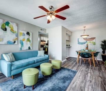 a living room with a blue couch and green chairs at Sundance Apartments, College Station, Texas