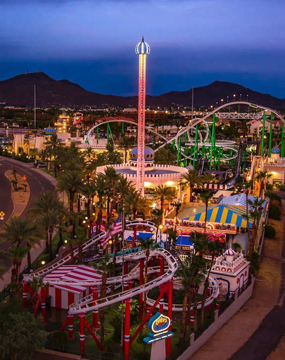 A roller coaster ride is lit up at night.