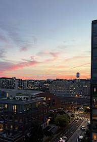 A cityscape at dusk with a water tower in the distance.