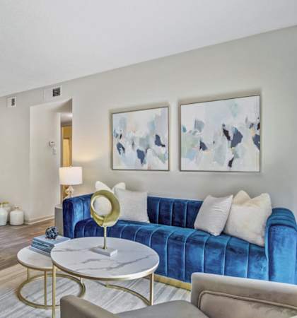 a living room with a blue couch and a table
