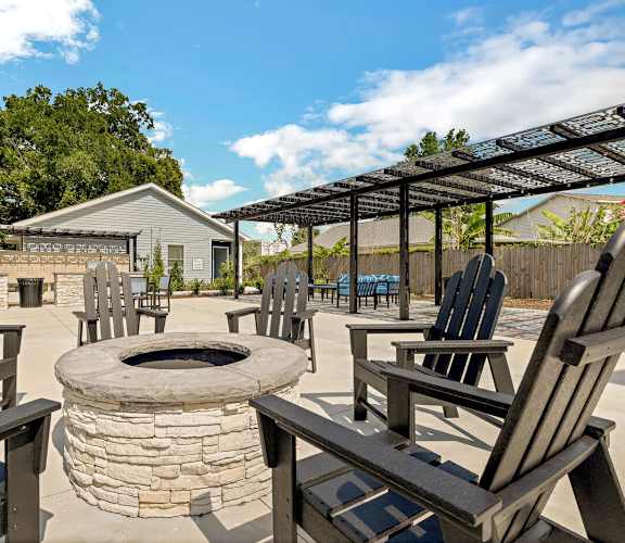 A patio with a fire pit and chairs.at The Papillon, Pensacola