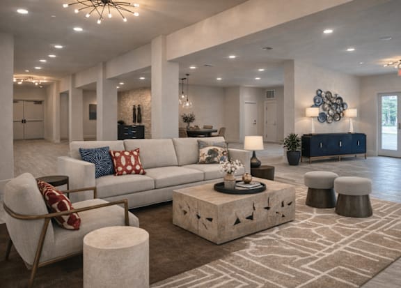 A spacious living room with a white sofa, a stone coffee table, and a large rug.
