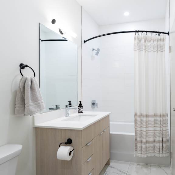A bathroom with a white sink and a white toilet.