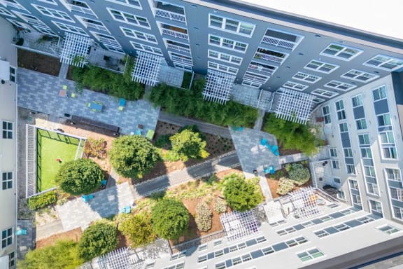 an aerial view of an apartment building with a green courtyard