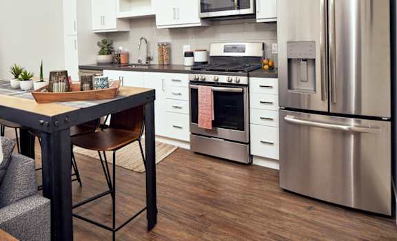 A modern kitchen with a stainless steel refrigerator and oven at Main+Nine, Riverside, 92501.
