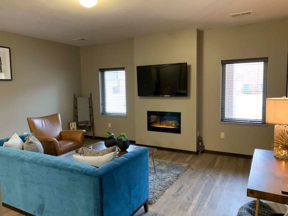 a living room with a blue couch and a fireplace