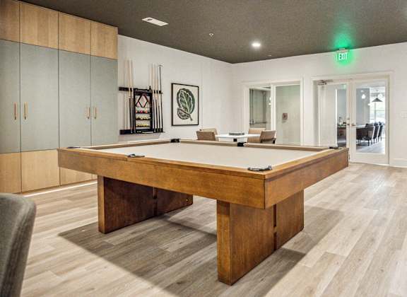 A room with a pool table and a chair.