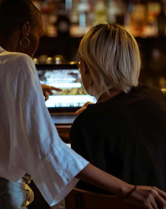 A woman with short blonde hair is sitting at a bar.