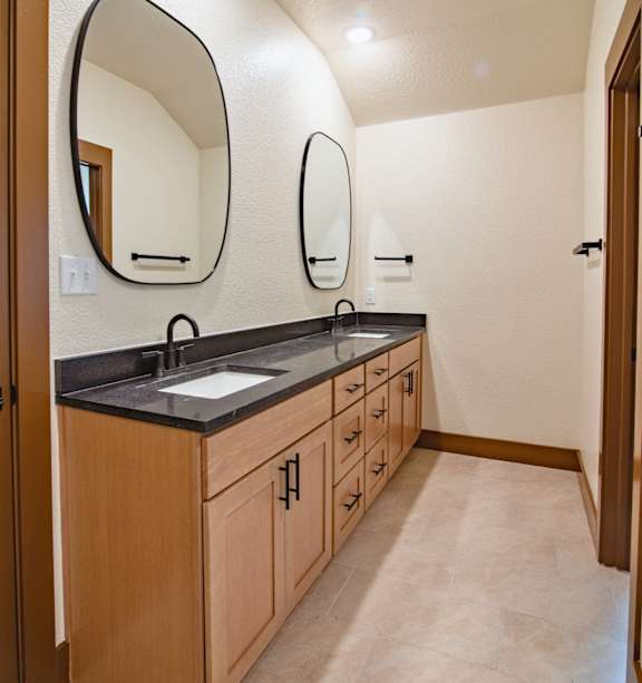 A bathroom with a sink and two mirrors.