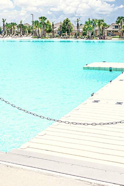 A wooden dock leads into a bright blue pool.