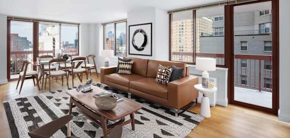 A living room with a brown couch and a coffee table at The Ellington Apartments, New York, NY, 10019