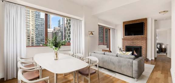 A living room with a fireplace and a TV on the wall at The Ellington Apartments, New York, NY, 10019