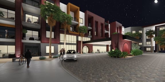 A nighttime scene of a modern apartment complex with people walking and a car parked.
