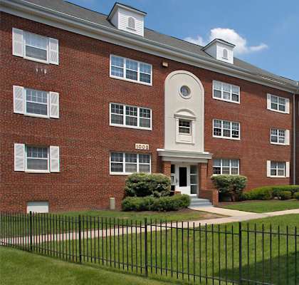 A red brick building with a black fence in front at University Landing Apartments, Silver Spring, Maryland