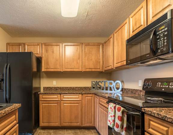 a kitchen with black appliances and wooden cabinets