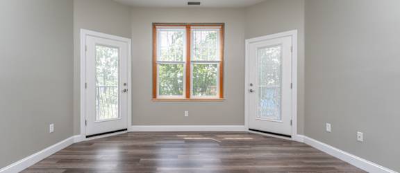 an empty room with two doors and a window