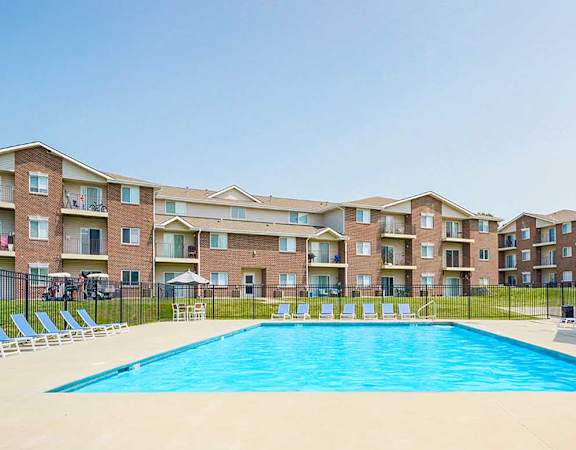 Poolside view with an apartment building in the background