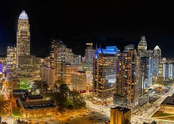 A cityscape at night with a variety of buildings and lights.