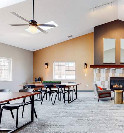 A clubhouse main room with a fireplace and multiple seating areas