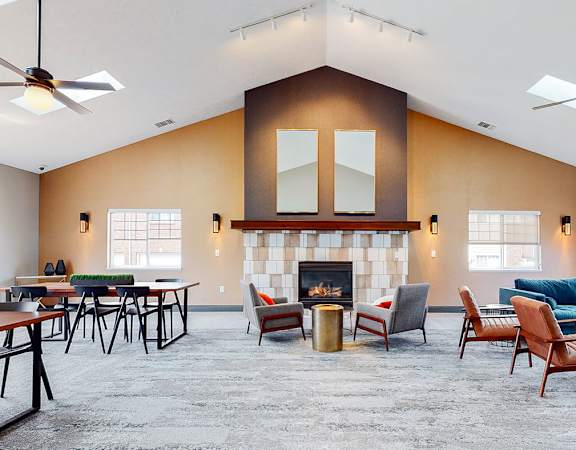 A clubhouse main room with a fireplace and multiple seating areas