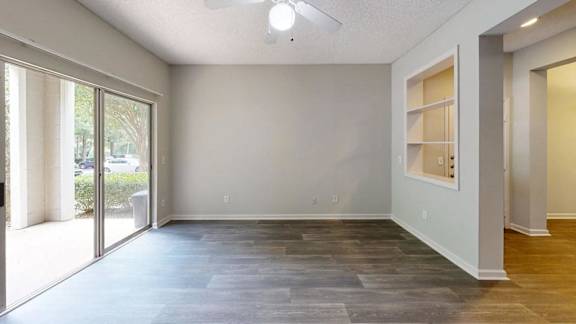 A room with a sliding glass door and a grey floor.