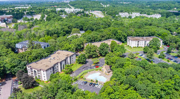 An aerial view of a large white building surrounded by trees.