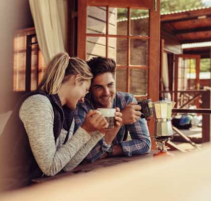 a couple sitting at a table drinking coffee at a window at Terracina, Broomfield, 80020