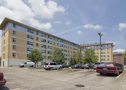 A parking lot with cars and a building in the background.