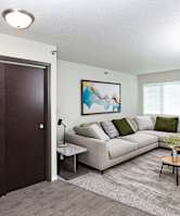 A living room with a couch, a coffee table, and a painting on the wall.