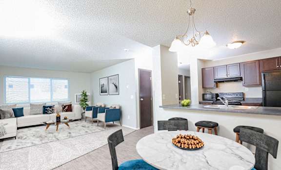 A modern living room with a dining table set for two.