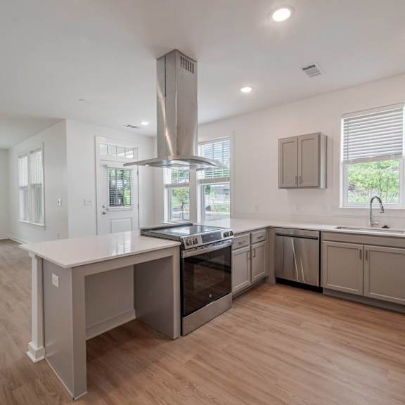 A modern kitchen with a large island and stainless steel appliances.