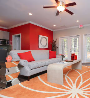 a living room with red walls and an orange rug