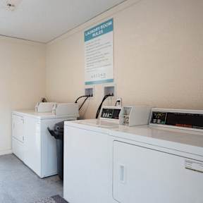 a laundry room with two washing machines and a door to the beach