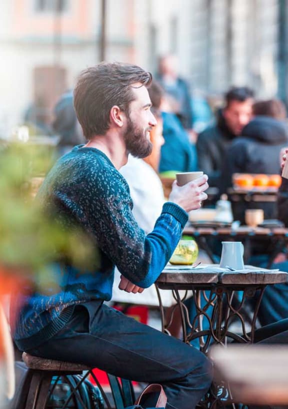 a man and a woman sitting at a table drinking coffee