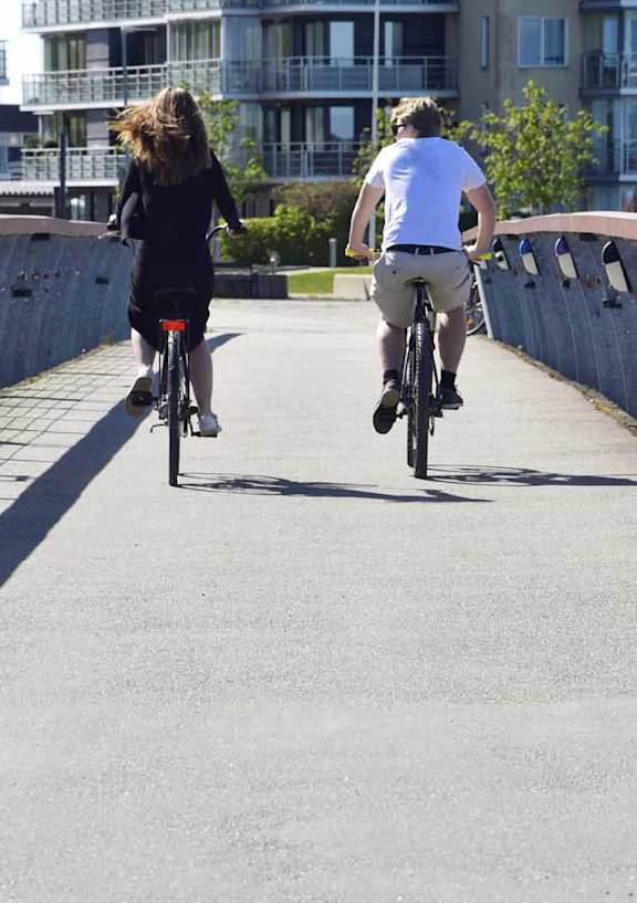 a man and a woman riding bikes on a bridge
