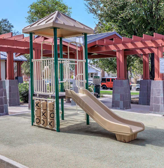 A playground with a slide and a red structure.