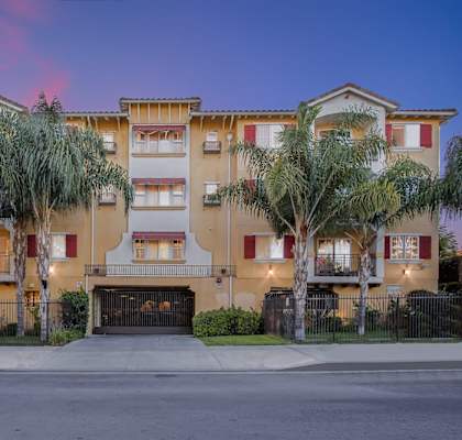 an apartment building with palm trees in front of it at Dronfield Astoria Apartments, Sylmar, California