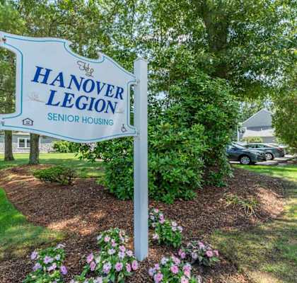 A sign for Hanover Legion Senior Housing stands in a landscaped area.