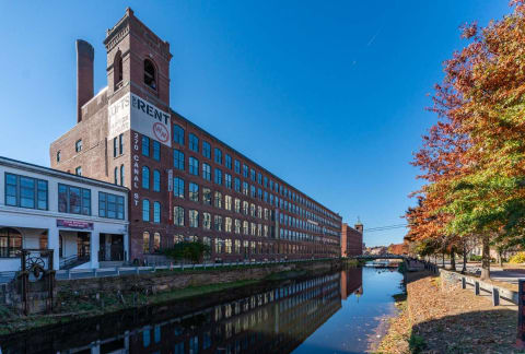 purple bridge over a river in front of a building