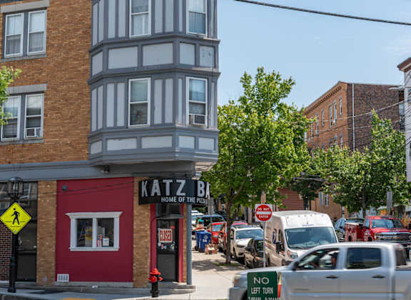 A street view with a red building on the left and a sign that says "No Left Turn".