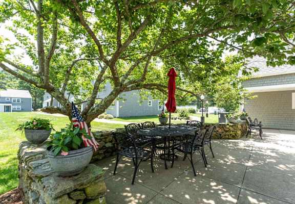 A patio with a table, chairs, and an American flag.