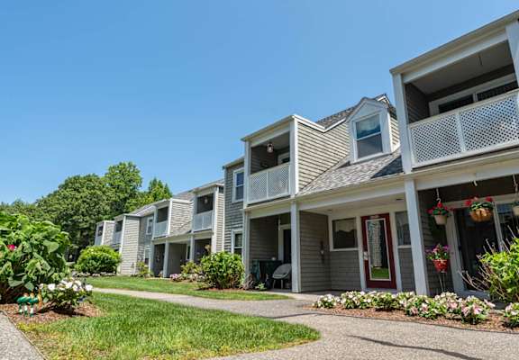 A row of townhouses with flower beds in front.
