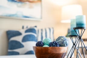 a close up of a wooden bowl on a table with a couch in the background