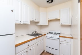 a kitchen with white cabinets and white appliances