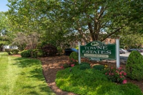 a sign in front of a building with a tree in the background