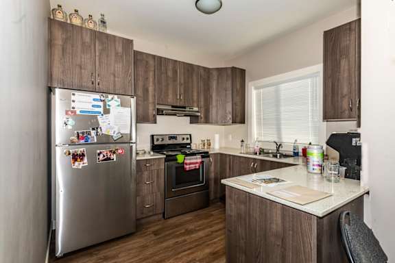 A kitchen with a refrigerator covered in magnets and notes.