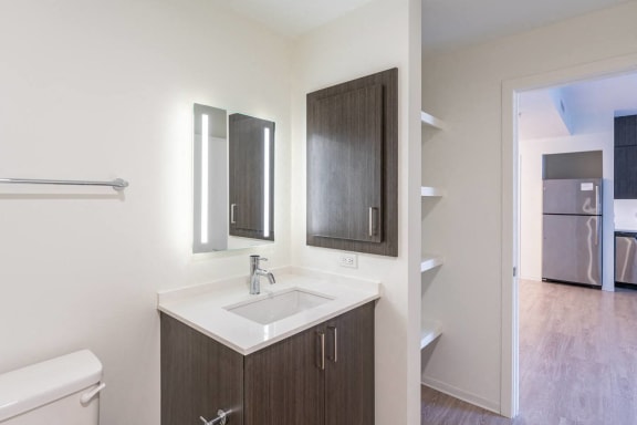 an empty bathroom with a sink and two mirrors