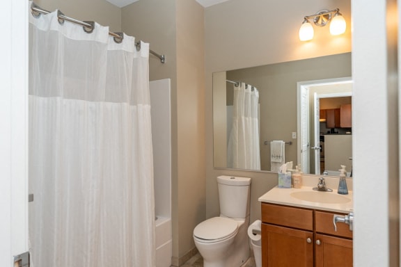 a bathroom with a shower and a toilet and a sink