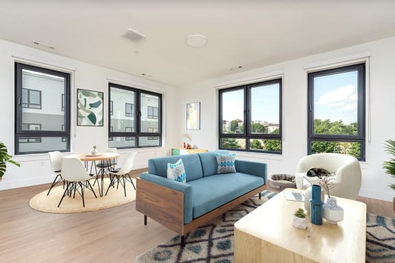a living room with a blue couch and a table and chairs