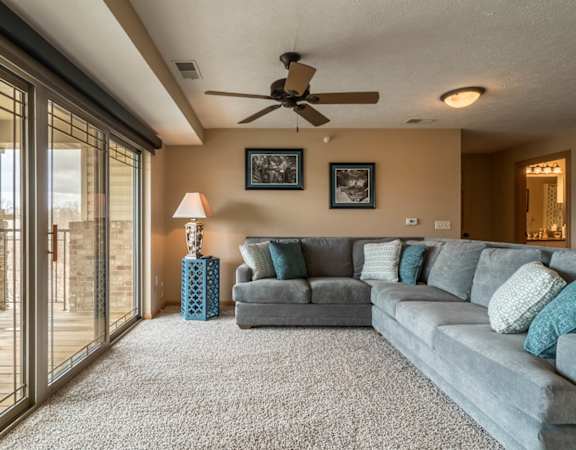 a living room with a couch and a ceiling fan